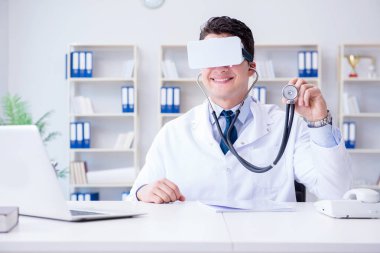 Sanal gerçeklik kulaklığı olan genç doktor ofiste çalışıyor.