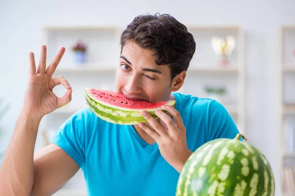 Man die thuis watermeloen eet — Stockfoto