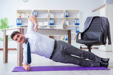 İş adamı ofisinde spor yapıyor.