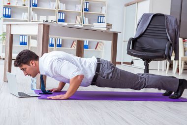 İş adamı ofisinde spor yapıyor.