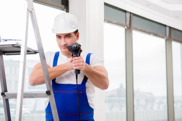 Reparador trabalhando com broca de energia na oficina — Fotografia de Stock