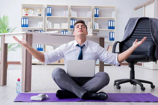 Adam stresle baş etmek için ofiste meditasyon yapıyor. — Stok fotoğraf