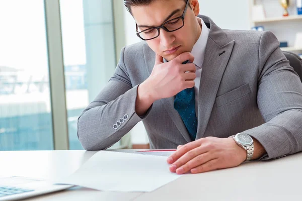 İşadamı ofiste iş belgelerini imzalıyor