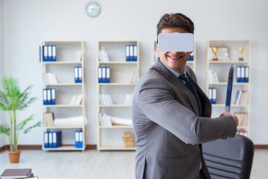 İş adamı VR gog ile ofiste sanal gerçeklik tenisi oynuyor