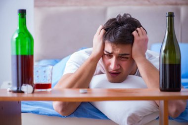 Yatakta içen alkolik adam depresyona giriyor.