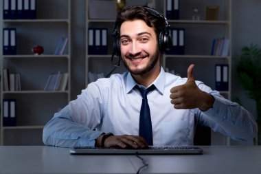 Çağrı merkezindeki genç adam geç saatlere kadar çalışıyor.