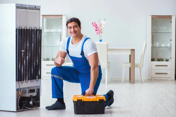 Repairman contractor repairing fridge in DIY concept