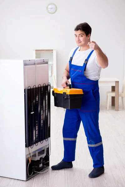 Repairman contractor repairing fridge in DIY concept