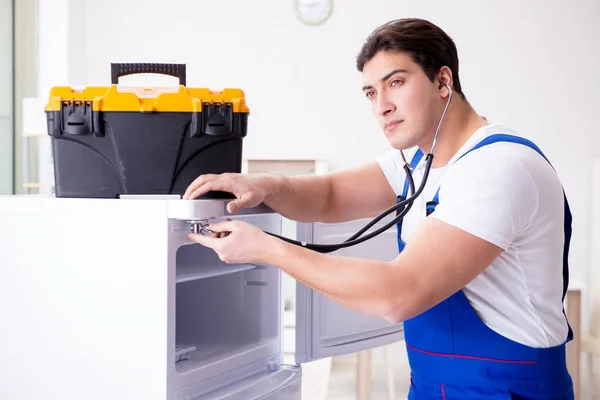 Repairman contractor repairing fridge in DIY concept