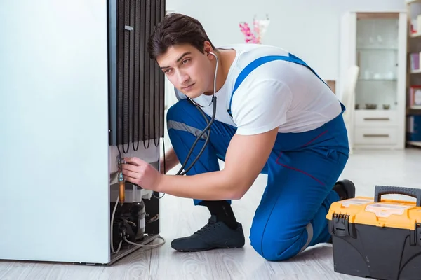 Tamirci müteahhit DIY konseptinde buzdolabını tamir ediyor.