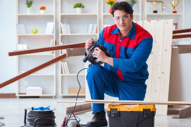 Genç marangoz ahşap kalaslarla çalışıyor.