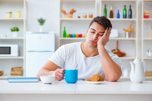 Человек засыпает во время завтрака после сверхурочной работы — стоковое фото