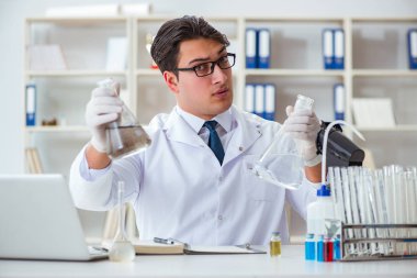 Genç araştırmacı bilim adamı bir su testi kirliliği araştırması yapıyor.