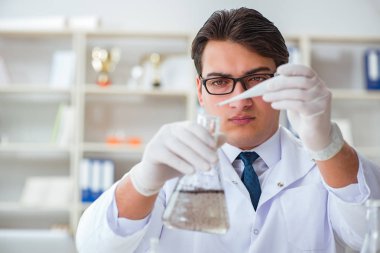 Genç araştırmacı bilim adamı bir su testi kirliliği araştırması yapıyor.