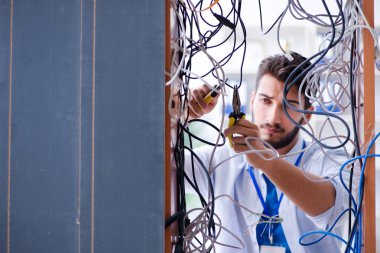 Elektrik teknisyeni tamir konseptinde kabloları çözmeye çalışıyor.