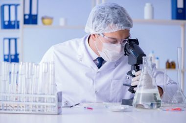 Laboratuvardaki adam yeni temizlik çözeltisi deterjanı test ediyor.