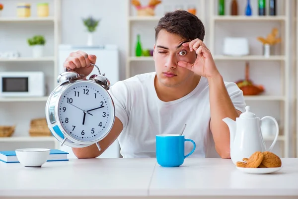 Homem com despertador adormecendo no café da manhã — Fotografia de Stock