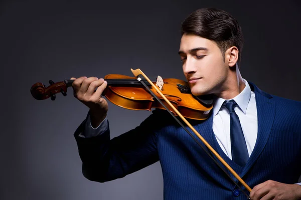 Young man playing violin in dark room — Stock Photo, Image