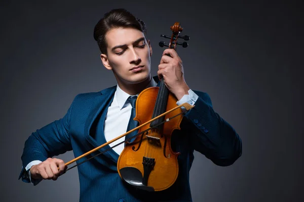 Jovem tocando violino no quarto escuro — Fotografia de Stock