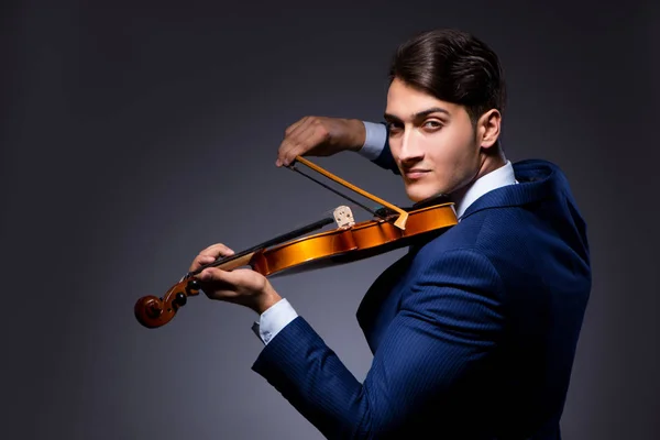 Jeune homme jouant du violon dans la chambre noire — Photo