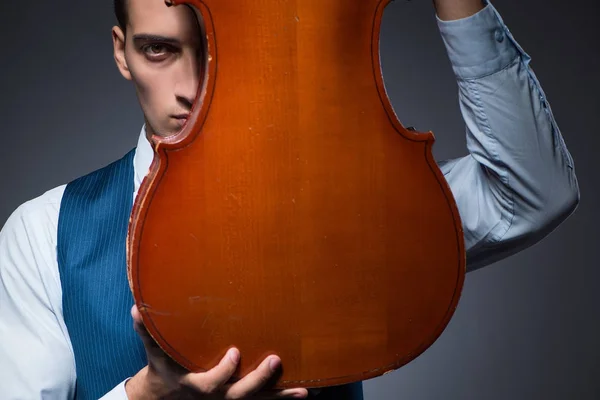 Jovem tocando violoncelo no quarto escuro — Fotografia de Stock