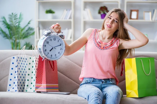 Młoda kobieta z torbami na zakupy w domu na kanapie — Zdjęcie stockowe