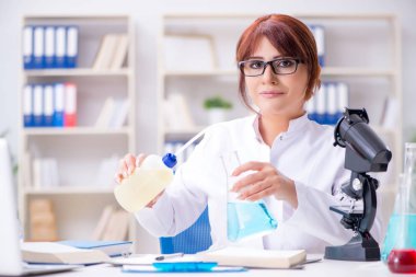 Bir laboratuarda deney yapan kadın bir bilim adamı.