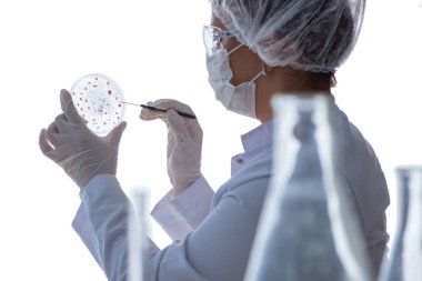 Bir laboratuarda deney yapan kadın bir bilim adamı.