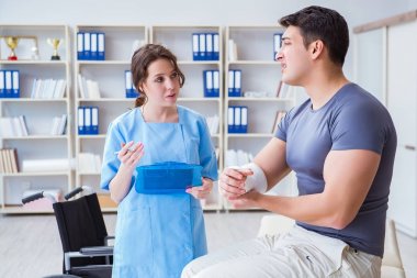 Hastanede yaralanma kontrolü sırasında doktor ve hasta.