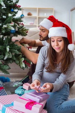 Genç aile Noel 'i kutlayan bir bebek bekliyor.