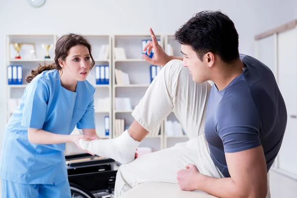 Hastanede yaralanma kontrolü sırasında doktor ve hasta.