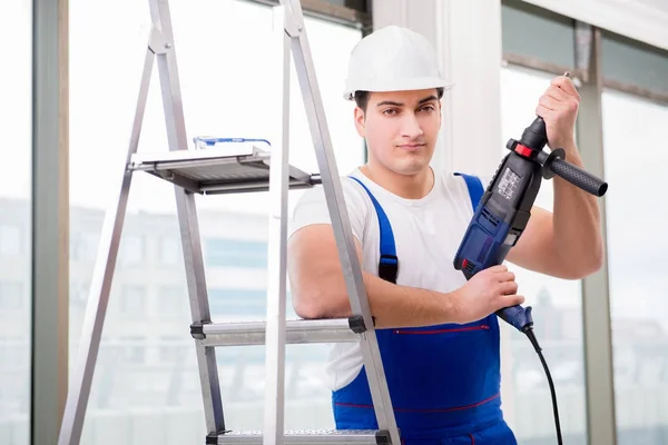 Reparador trabalhando com broca de energia na oficina — Fotografia de Stock