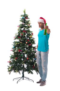 Genç adam beyaz üzerine izole edilmiş noel ağacını süslüyor.