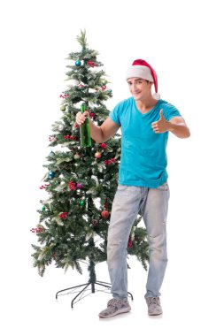 Genç adam beyaz üzerine izole edilmiş noel ağacını süslüyor.