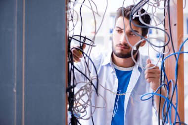 Elektrik teknisyeni tamir konseptinde kabloları çözmeye çalışıyor.
