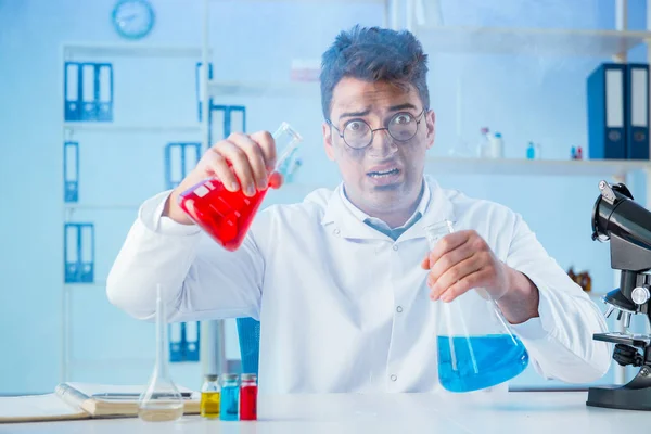 Zabawny szalony chemik pracujący w laboratorium. — Zdjęcie stockowe