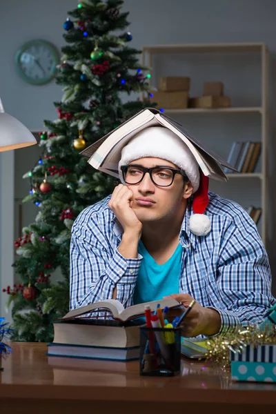 Młody człowiek pracujący w domu w Boże Narodzenie — Zdjęcie stockowe