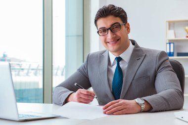 İşadamı ofiste iş belgelerini imzalıyor