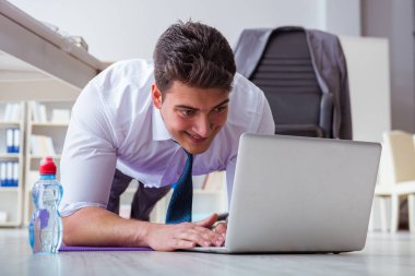 İş adamı ofisinde spor yapıyor.