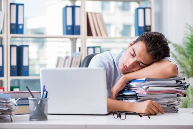 Yorgun iş adamı ofiste oturuyor.