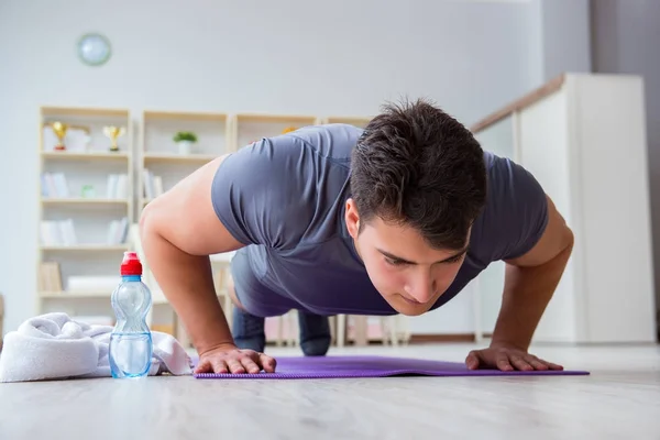 Junger Mann trainiert zu Hause mit Sport und gesundem Lebensstil — Stockfoto