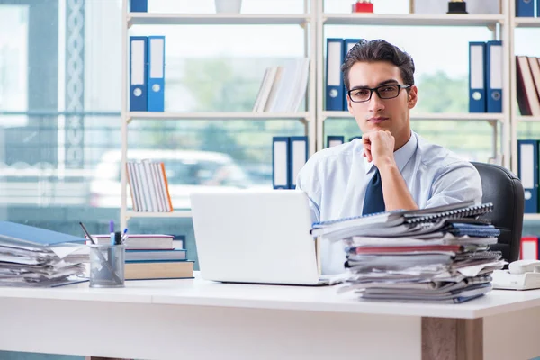 Homme d'affaires avec une paperasserie de travail excessive travaillant dans le bureau — Photo