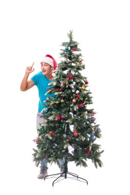 Genç adam beyaz üzerine izole edilmiş noel ağacını süslüyor.