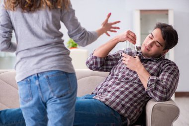 Genç bir aile kavramında içki sorunu yaşayan sarhoş bir koca.