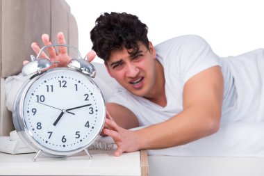 Yatakta uykusuzluk çeken bir adam.