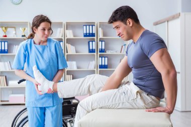 Hastanede yaralanma kontrolü sırasında doktor ve hasta.