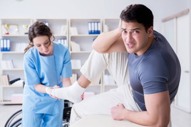 Hastanede yaralanma kontrolü sırasında doktor ve hasta.