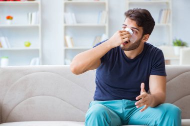 Genç adam estetik cerrahi burnundan sonra evde iyileşiyor.