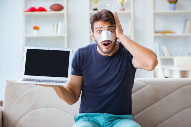 Genç adam estetik cerrahi burnundan sonra evde iyileşiyor.