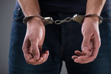 Elleri kelepçeli bir adam ceza konseptiyle